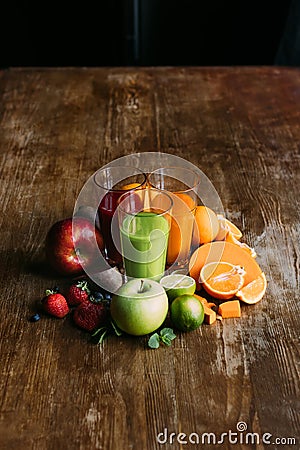 high angle view of various smoothies in glasses and fresh fruits with vegetables on wooden Stock Photo